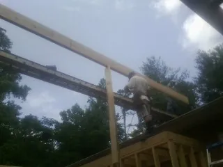 Carpenter setting a ridge beam over a new addition frame — Ice Dam Removal by Roofing Brothers in Tow