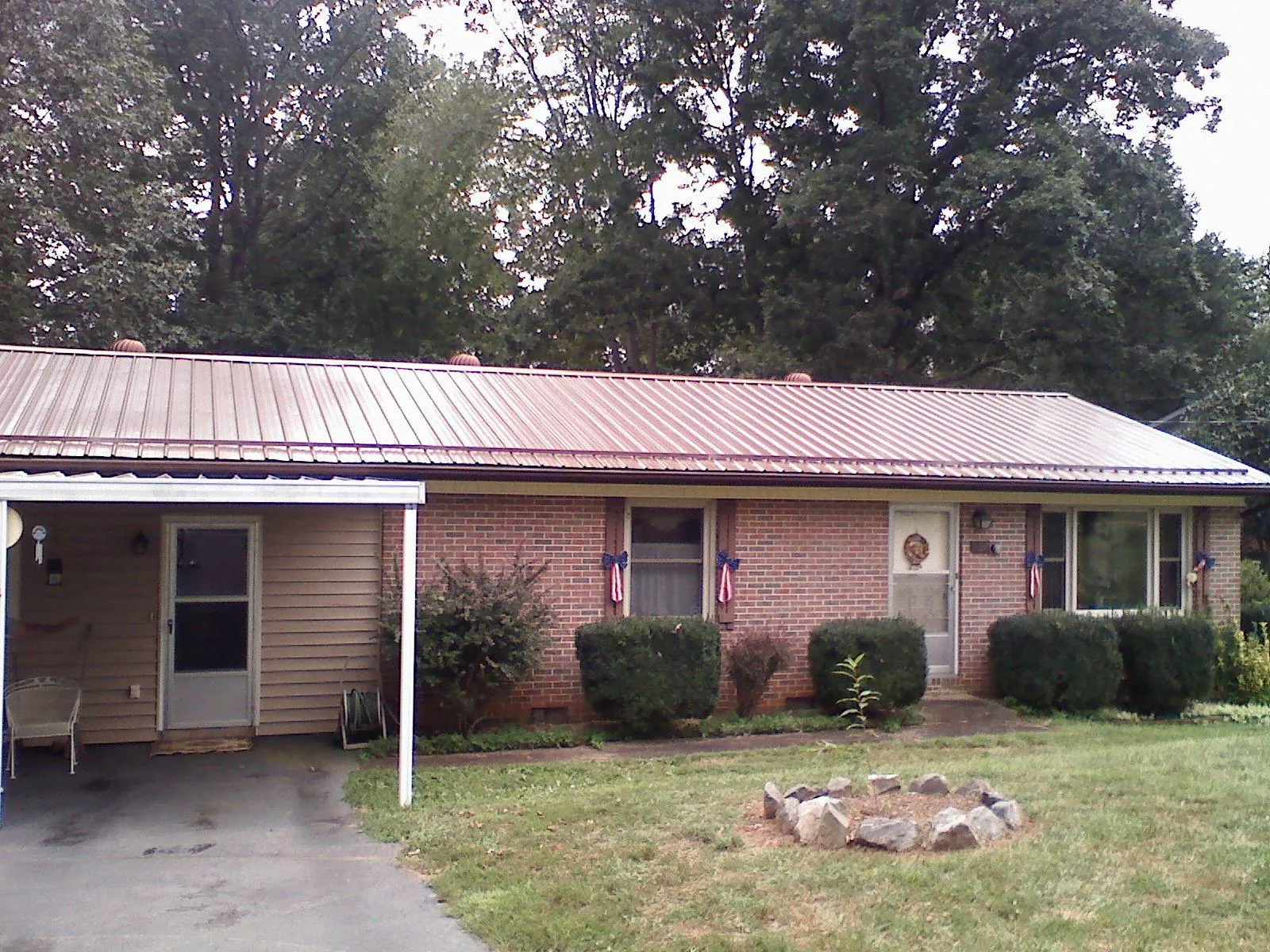 Bronze metal roof and carport on a brick ranch home — Roof Repair work by our crew in Tow